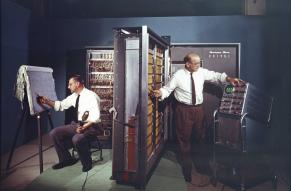 Color image of two men installing a large UNIVAC computer