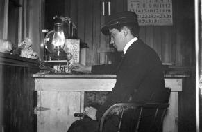 Black and white image of a telegraph operator at work in an office in 1904.