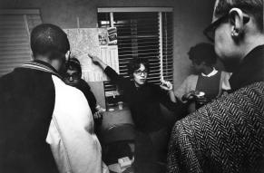 Group of anti-poverty and racial justice activists in an office and consulting a transit map.