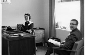 Black and white photograph taken inside an office inside the Hagley Library building. Left to right: Miss Betty Foster, Mr. Edward Ezell.