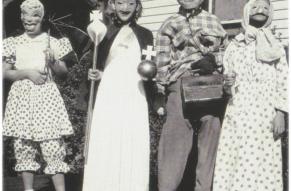 Black and white image of four fifth grade children in 1950s Halloween costumes