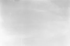 Black and white photo of a ship sailing on the ocean. There is no land in sight, just water.