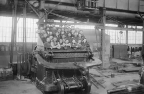 Black and white photograph of a group of workers posed inside a large dredge dipper.
