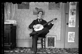 Black and white image of a young man playing a banjo