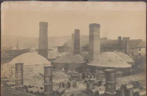 Industrial site with large structures and chimneys.