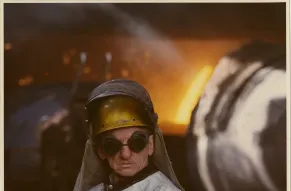Color photograph of a steelworker in protective clothing
