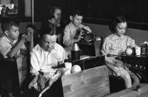 Black and white photograph of children seated at school desks.