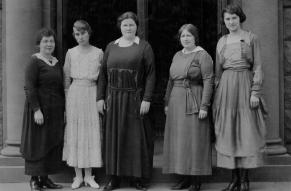 Black and white image of five women on the steps of a school