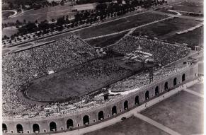 Black and white aerial photograph of an open-air stadium full of people