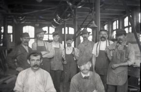 Black and white image of workers posed for a photograph inside a carpenters' shop.