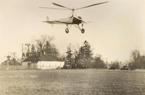 Photograph of an autogiro lifting from the ground at an airfield