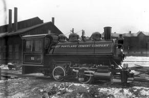 Black and white image of a locomotive in a train yard.