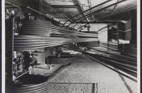 Black and white photo showing a well-composed image of large industrial rolls of cordage.