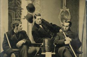 Posed portrait of William and Charles Green, and Albert Studebaker, with powder container