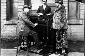 Two men and a woman, arrayed around a 'color organ', which resembles a small, if unusual, piano.