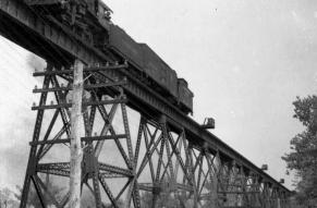 Black and white image of a steam-powered locomotive operated by the Pennsylvania Railroad on the elevated Octoraro Bridge near Oxford, Pennsylvania