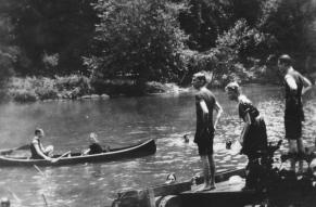 Black and white photograph of people swimming and canoeing in the Brandywine River