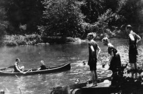 Black and white image of people canoeing and swimming in the Brandywine River