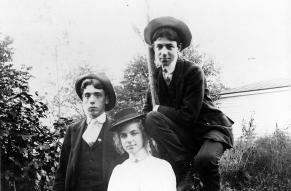 Black and white image of three young people in their late teens; two young men and a woman.