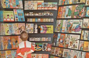Ad for children's activity books and games showing a little girl perusing a large rack of products.