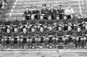 Group photo of the Pennsylvania Railroad's 1926 football team, seated on wooden bleachers.