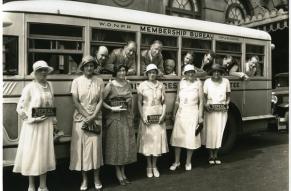 Photograph of women from the Women's Organization for National Prohibition Reform, posed with signs in front of a bus with men looking out the window